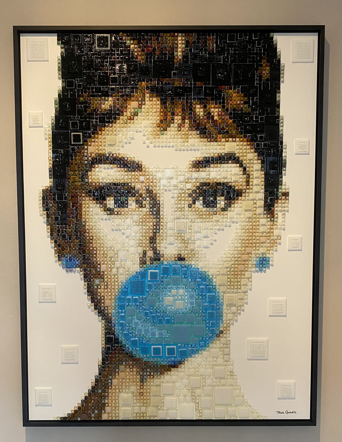 George Michael – GlassArt van Tessa van Thienen George Michael van glaskunstenares Tessa van Thienen is een krachtig en iconisch GlassArt-kunstwerk waarin muziek, stijl en emotie samenkomen. In haar herkenbare pop-art stijl weet Tessa de charismatische uitstraling, kwetsbaarheid en tijdloze klasse van George Michael treffend te vangen. Geïnspireerd door de muziek- en modewereld vertaalt zij zijn persoonlijkheid naar een gelaagd portret van duizenden zorgvuldig gesneden stukjes glas, samengesmolten tot een glamoureus en expressief geheel. Het spel van licht, kleur en diepte geeft het werk een levendige uitstraling die blijft veranderen afhankelijk van het perspectief. Dit bijzondere portret is een echte statement piece en perfect voor liefhebbers van moderne kunst, popcultuur en iconische muzieklegendes. Een eerbetoon aan een artiest die generaties blijft inspireren, uitgevoerd in de verfijnde en exclusieve glastechniek van Tessa van Thienen.